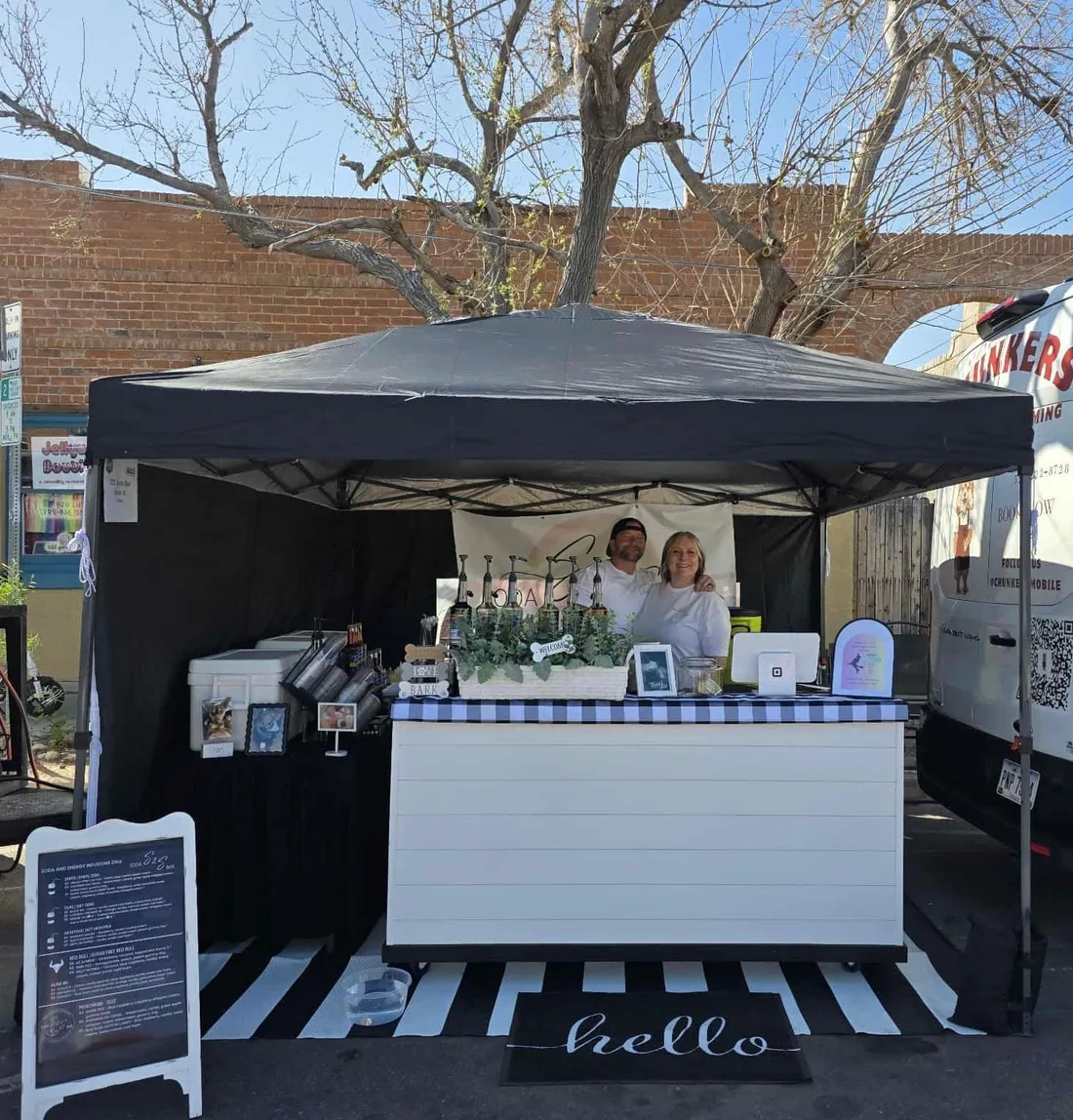 Bobbie and Jarrod at the S2S Soda Bar booth at an outdoor festival